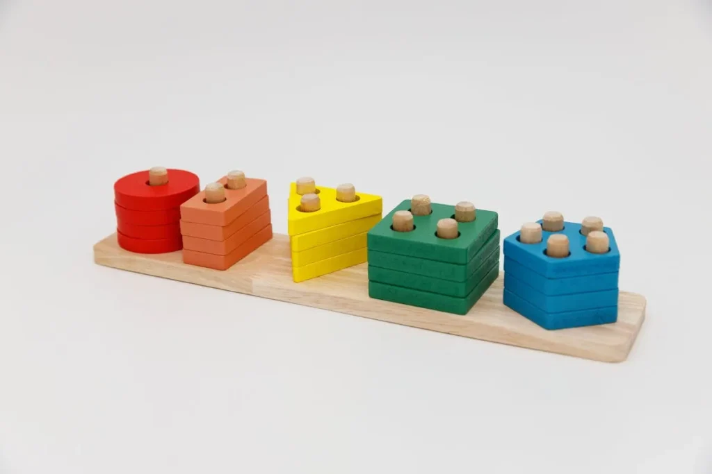 Enfant jouant avec des jeux Montessori en bois colorés et éducatifs