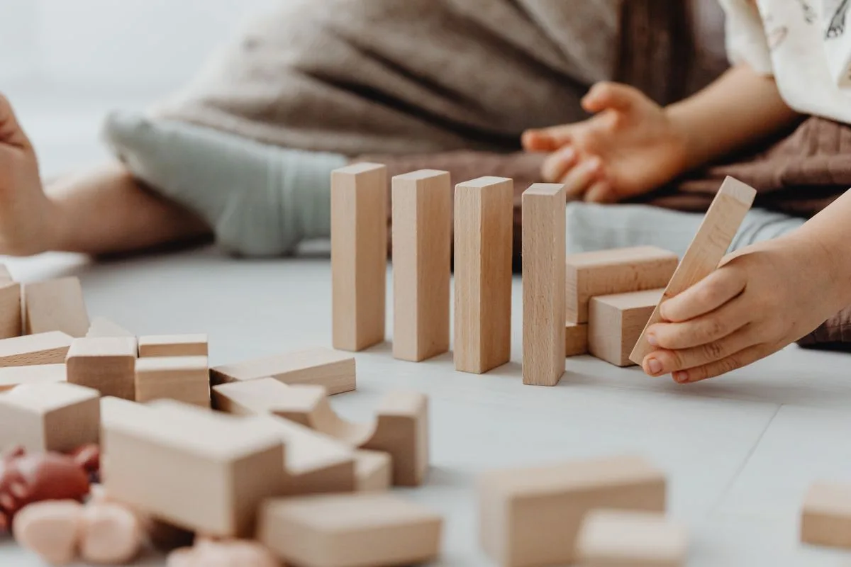 Motricité fine Montessori : enfant plaçant un bloc avec concentration