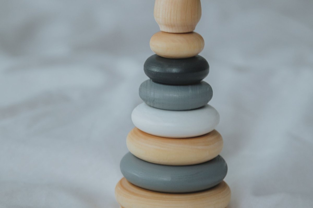 Empileur anneaux en bois naturel Montessori pour bébé sur fond doux