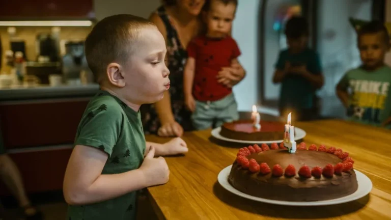 Enfant soufflant les bougies de son anniversaire